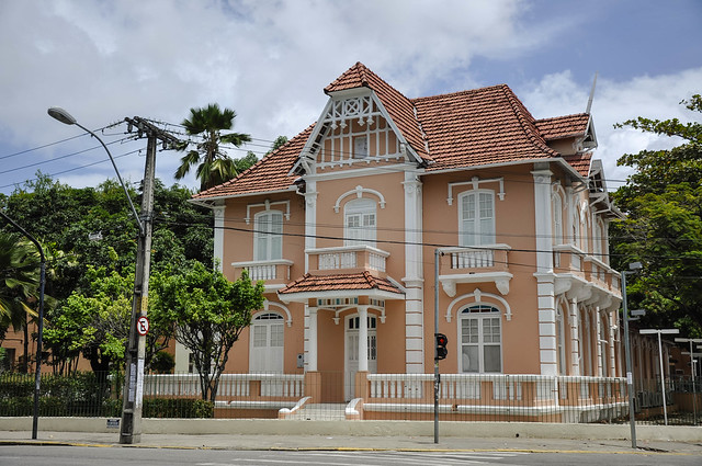 São ofertadas 1.261 vagas, sendo 762 para o nível inicial e 499 para o teste de nível (Foto: Rafael Cavalcante/UFC) Imagem: Foto da fachada de um sobrado rosa com detalhes branco. Ao lado dele, há uma árvore e um poste de iluminação pública