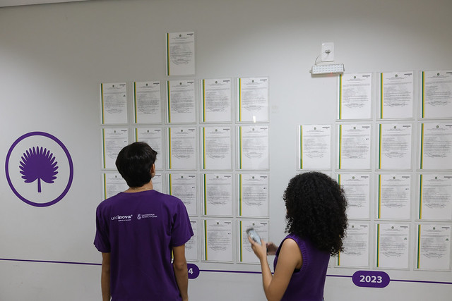 O processo de ampla concorrência selecionará a proposta mais vantajosa para a exploração das tecnologias, observando critérios técnicos, econômicos e de interesse público (Foto: Victor Braga/UFC) Fotografia de dois jovens observando mural com as cartas-patente concedidas à UFC (Foto: Victor Braga/UFC)
