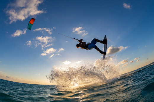 O curso tem como objetivo apresentar procedimentos e protocolos relacionados à gestão de riscos na prática do kitesurf (Foto: Magnific.com) Homem em cima da prancha de kitesurf em alto mar